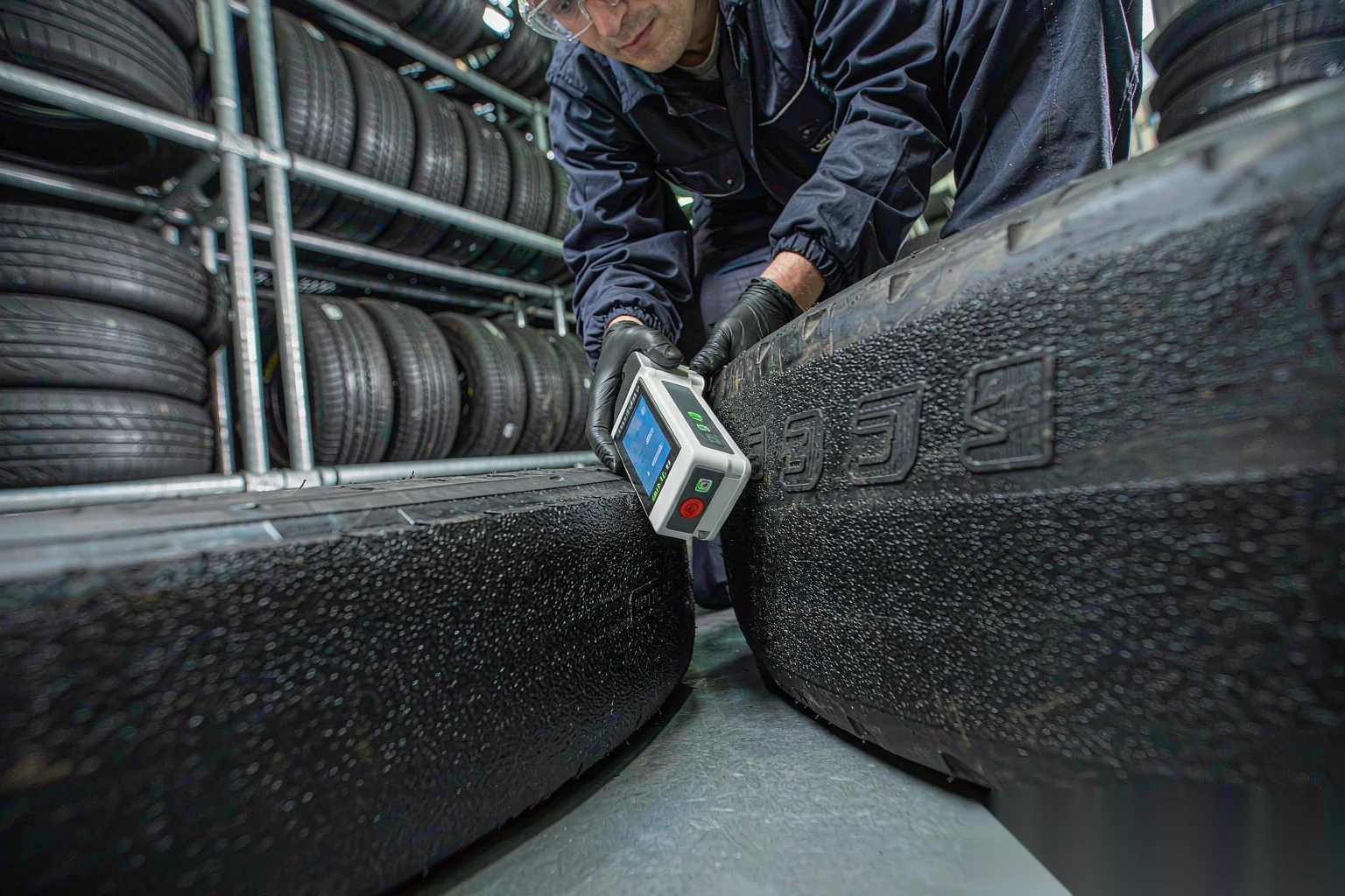 工程师用手持 UHF 读写器扫描卡车轮胎上的嵌入式 RFID 标签